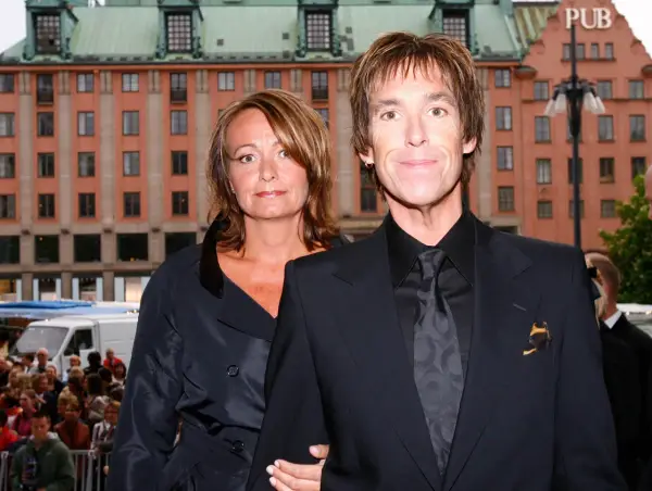 Gessle, ung och stilig, poserar med en kvinna framför en byggnad i Stockholm.